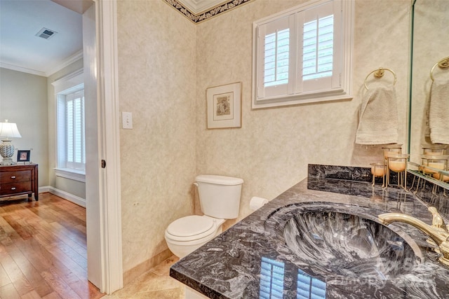 bathroom featuring crown molding, plenty of natural light, vanity, and toilet