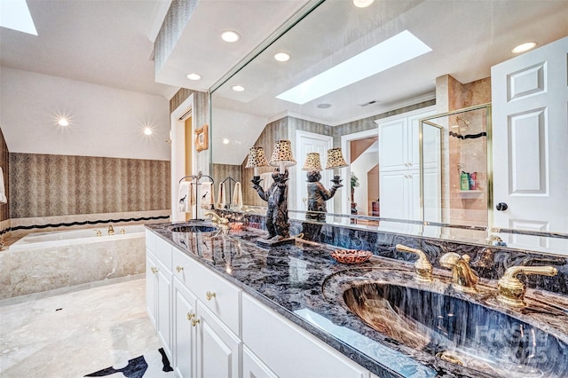 bathroom featuring vanity, a skylight, and independent shower and bath