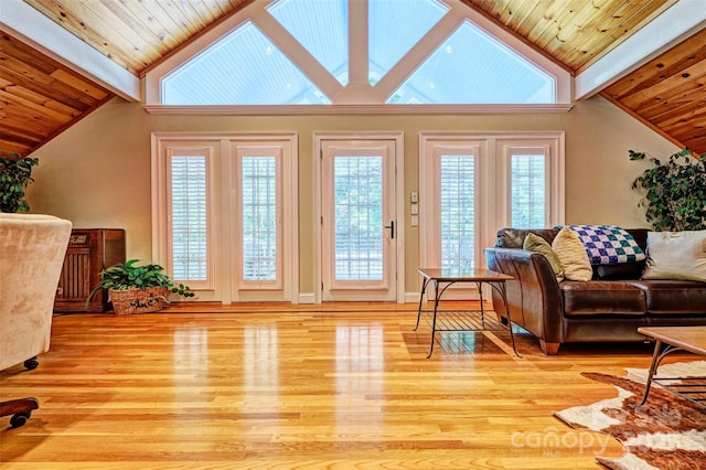 living room with light hardwood / wood-style floors and high vaulted ceiling