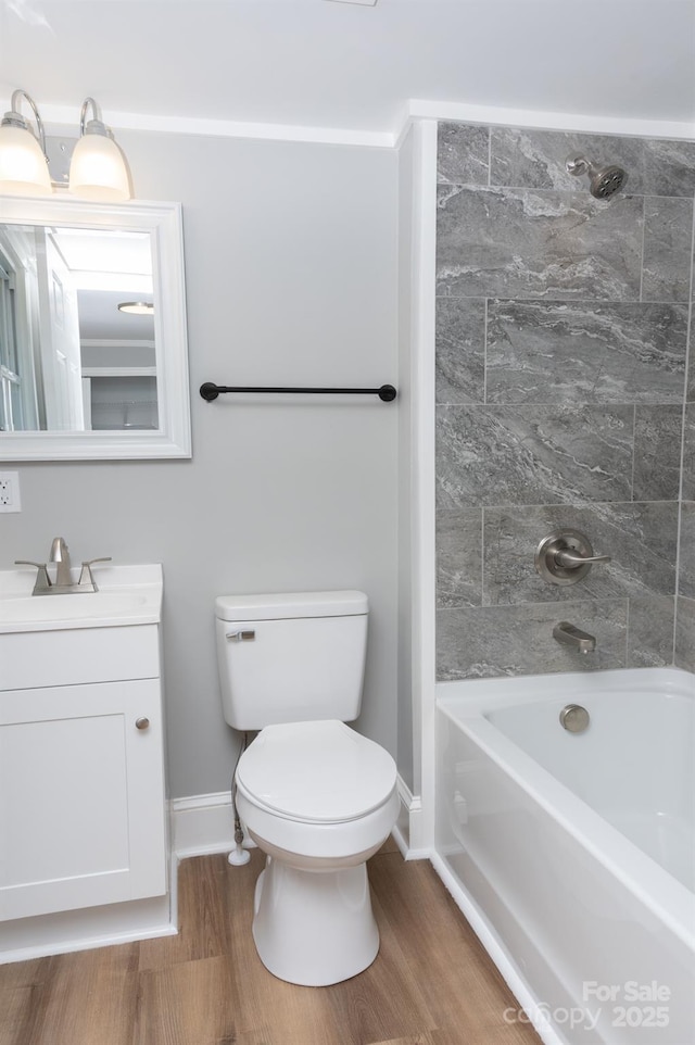 full bathroom with hardwood / wood-style floors, tiled shower / bath combo, vanity, and toilet