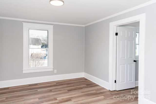 empty room with ornamental molding and light hardwood / wood-style flooring