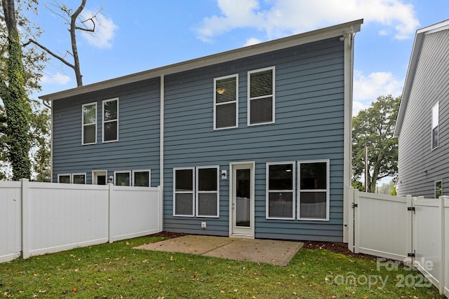 rear view of house with a patio area and a lawn