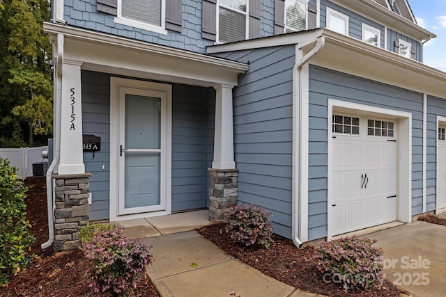 entrance to property with central air condition unit and a garage