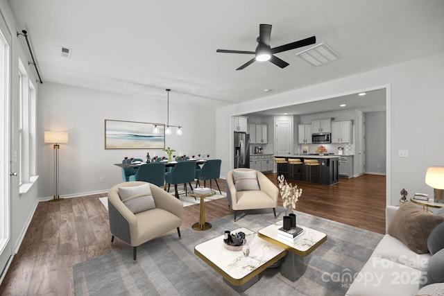 living room featuring ceiling fan and dark hardwood / wood-style floors