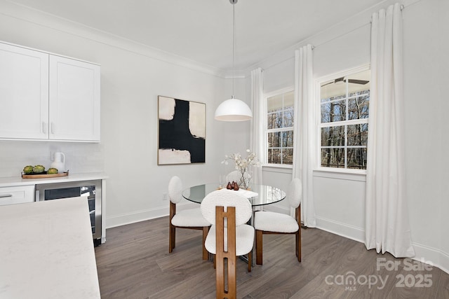 dining room with beverage cooler, dark wood-type flooring, and ornamental molding