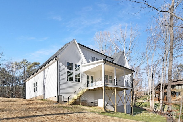 rear view of property featuring ceiling fan and a balcony