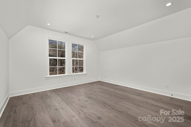 additional living space featuring wood-type flooring, a wealth of natural light, and vaulted ceiling