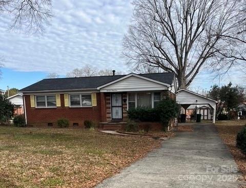 ranch-style house with a carport and a front lawn