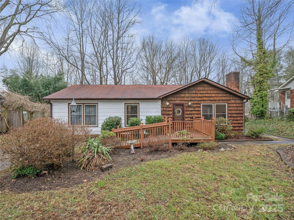 view of front facade featuring a deck and a front yard