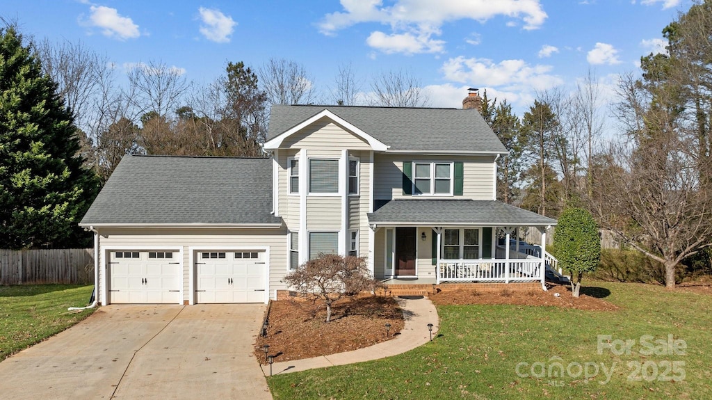 front of property with covered porch, a front yard, and a garage