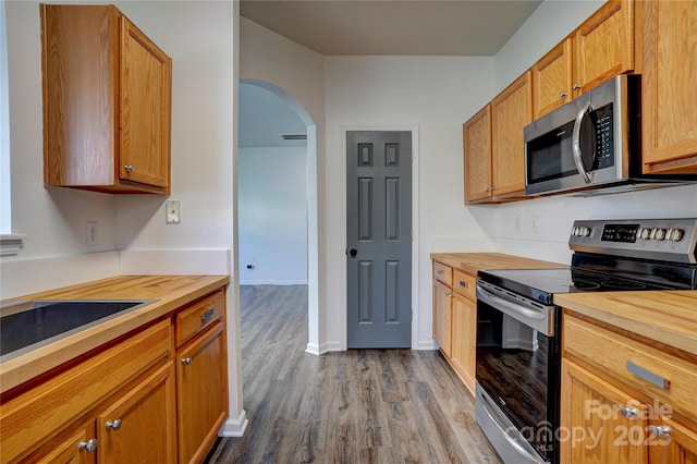 kitchen featuring wood counters, sink, wood-type flooring, and stainless steel appliances