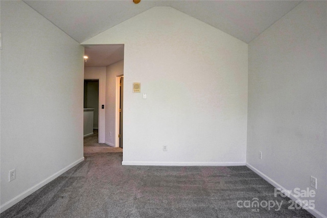 carpeted spare room featuring vaulted ceiling