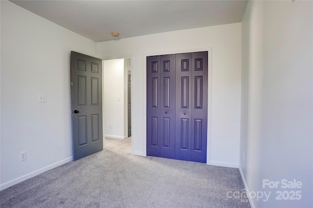 unfurnished bedroom with light carpet and a closet