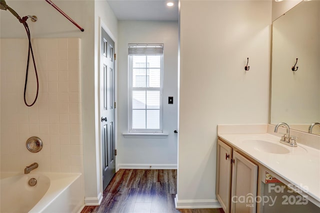 bathroom featuring hardwood / wood-style floors, vanity, and tiled shower / bath