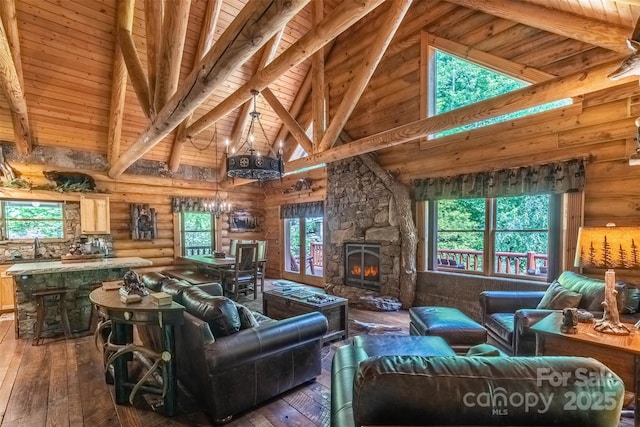 living room featuring beam ceiling, a fireplace, log walls, and wood ceiling