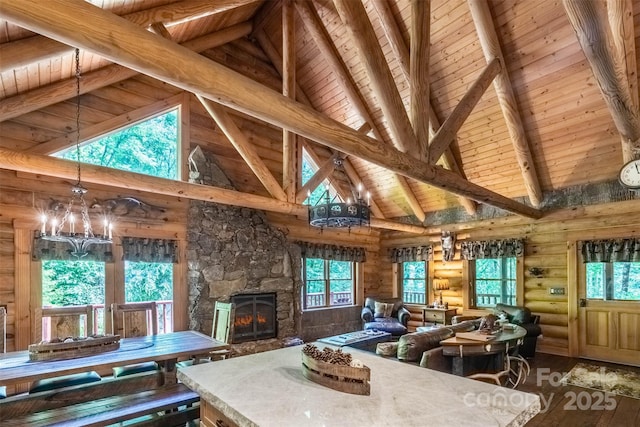 living room with log walls, high vaulted ceiling, wooden ceiling, beamed ceiling, and a fireplace