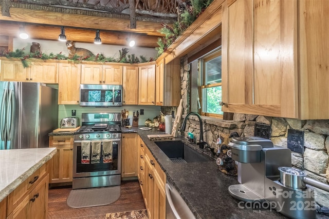 kitchen with sink, dark stone countertops, tasteful backsplash, dark hardwood / wood-style flooring, and stainless steel appliances