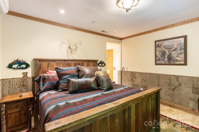 bedroom with ornamental molding and an AC wall unit