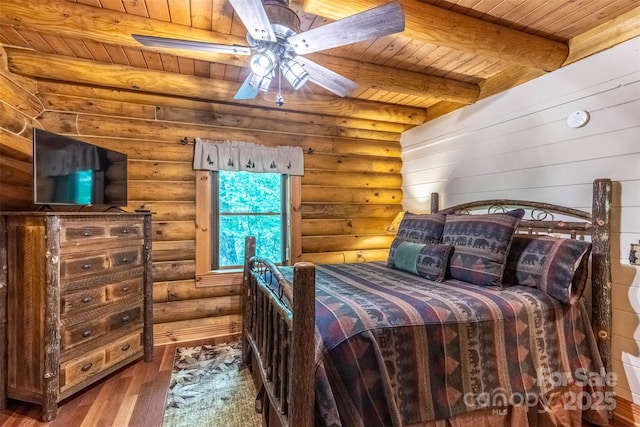 bedroom with beam ceiling, ceiling fan, log walls, wood-type flooring, and wood ceiling