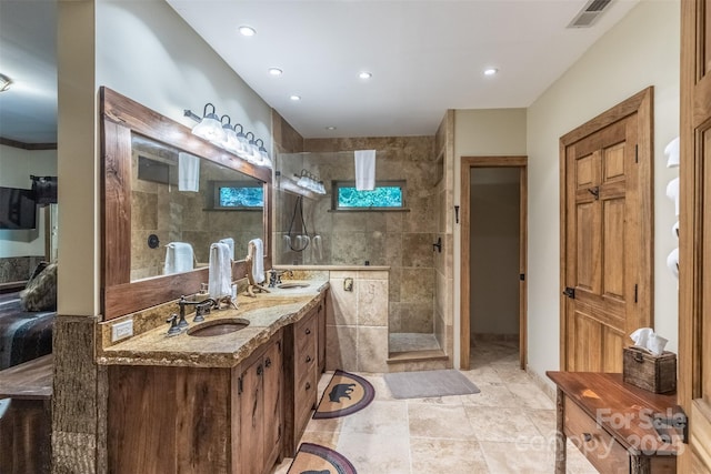 bathroom featuring a tile shower and vanity