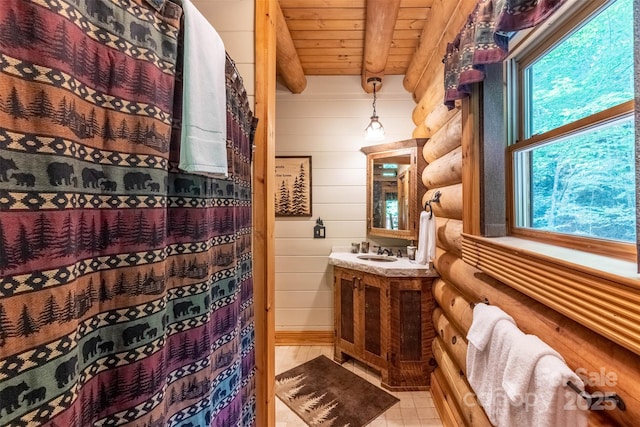 bathroom with beamed ceiling, vanity, rustic walls, and wood ceiling