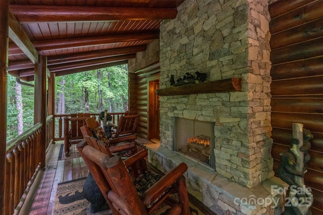 sunroom / solarium featuring a fireplace, beam ceiling, and wood ceiling