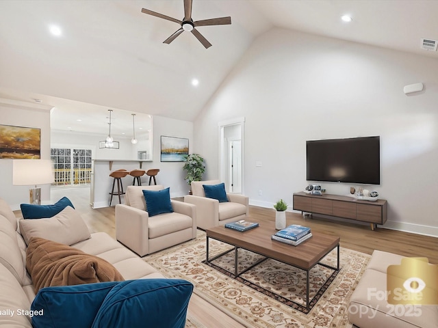 living room with light wood-type flooring, ceiling fan, and high vaulted ceiling