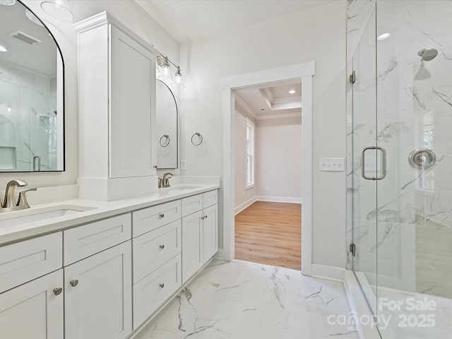 bathroom with a tray ceiling, a shower with door, and vanity