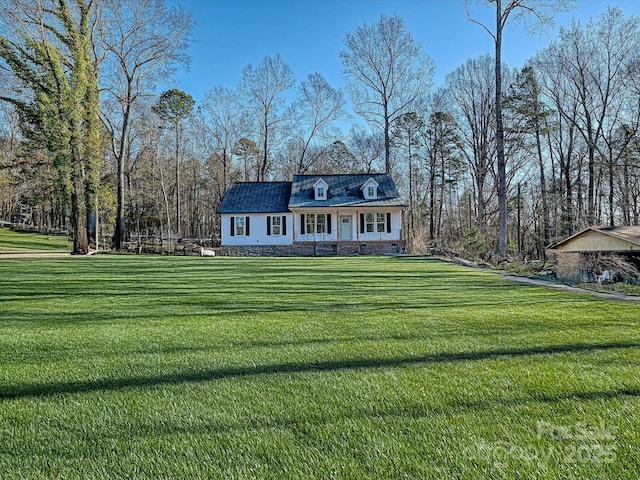 cape cod home featuring a front yard