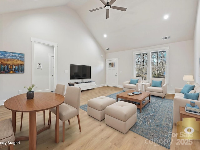 living room featuring ceiling fan, light hardwood / wood-style floors, and high vaulted ceiling