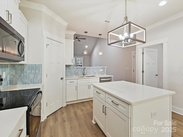 kitchen with tasteful backsplash, a center island, pendant lighting, electric range, and white cabinetry