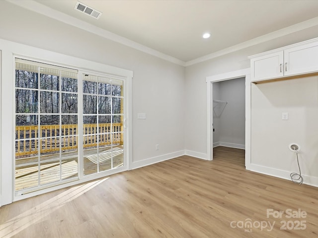 interior space with light wood-type flooring and ornamental molding