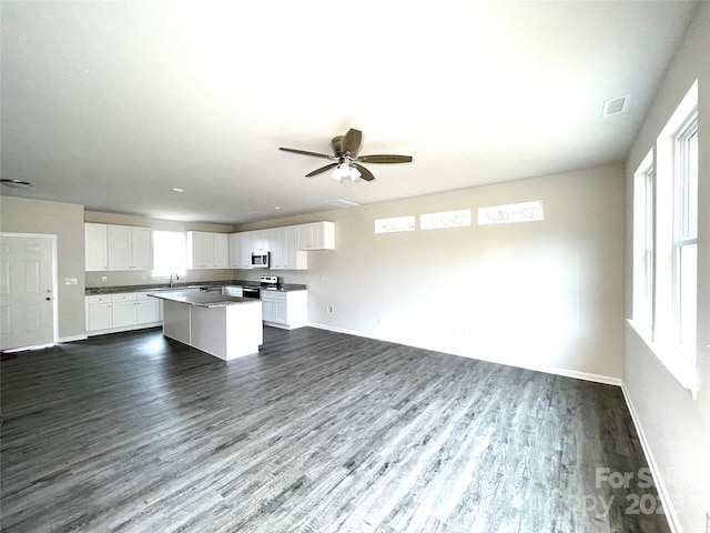 kitchen featuring stainless steel appliances, a kitchen island, ceiling fan, dark wood-type flooring, and white cabinetry