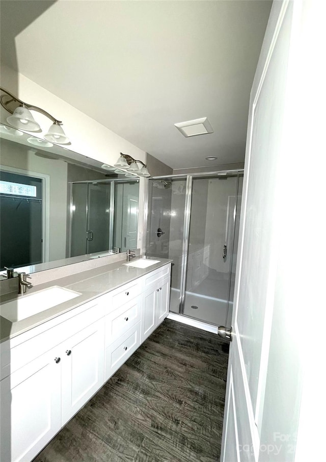 bathroom with wood-type flooring, vanity, and walk in shower