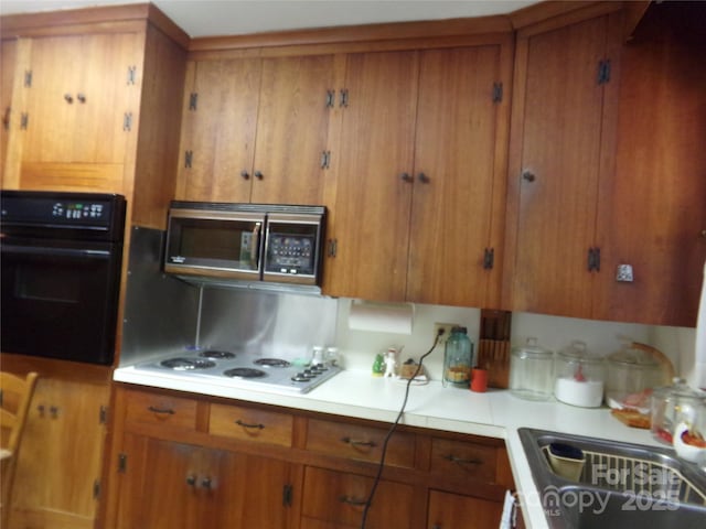 kitchen with white gas cooktop and black oven