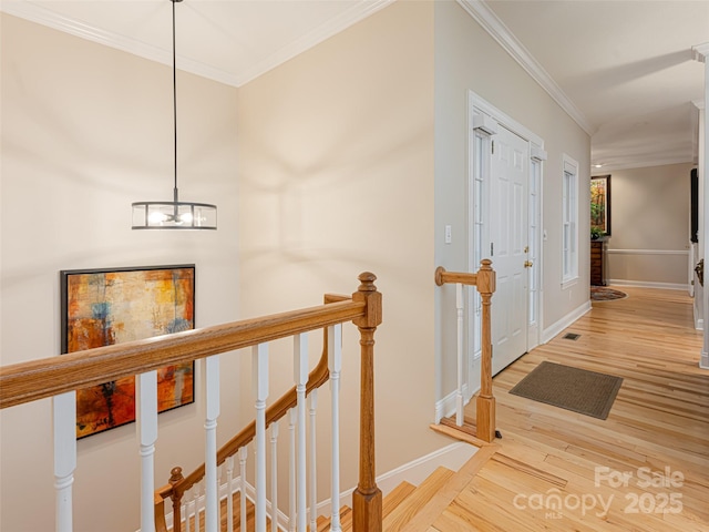 hall with hardwood / wood-style flooring, crown molding, and a notable chandelier