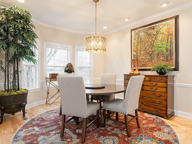 dining room featuring light wood-type flooring and ornamental molding