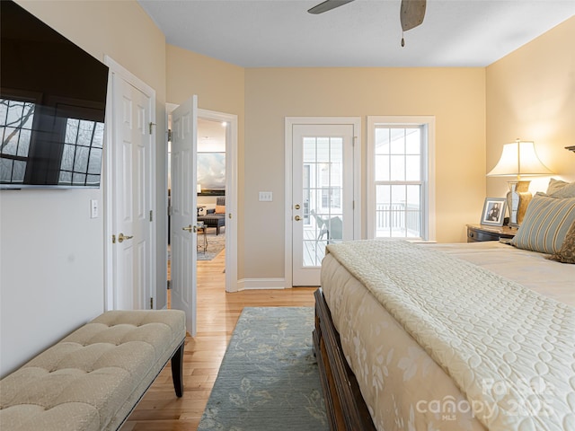 bedroom with access to outside, ceiling fan, and hardwood / wood-style floors