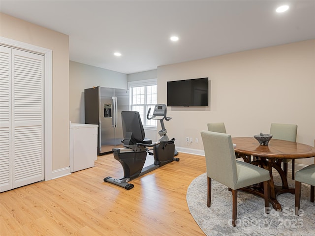 exercise room with light hardwood / wood-style flooring