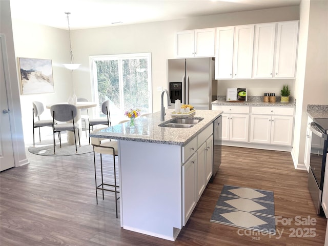 kitchen with pendant lighting, stainless steel appliances, white cabinetry, and sink