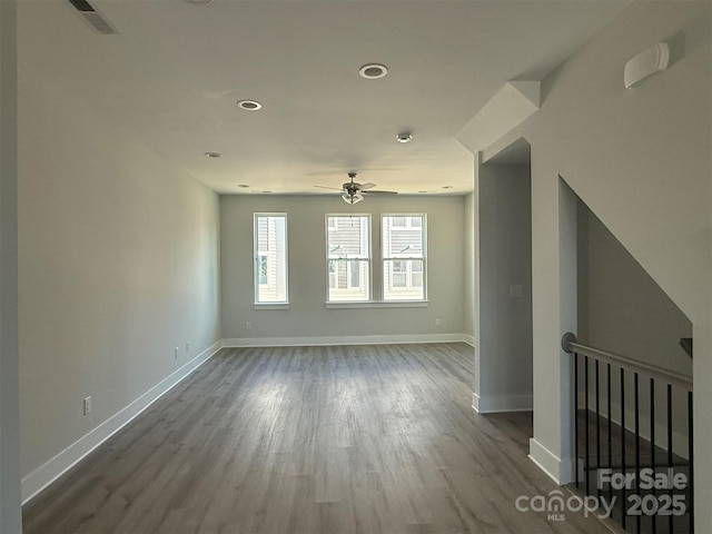 empty room featuring ceiling fan and dark wood-type flooring