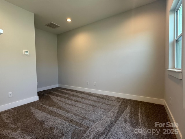 unfurnished room with dark carpet and a healthy amount of sunlight