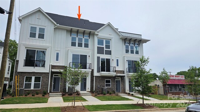 1225 E 34th St Unit Csw0419, Charlotte, NC 28205 - view of front of house featuring a balcony, board and batten siding, central AC, and brick siding