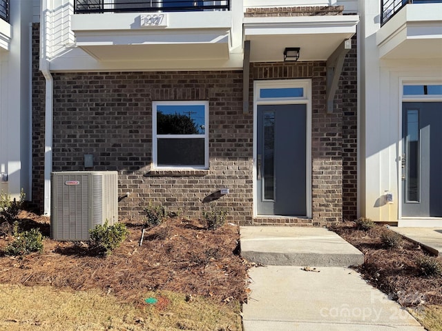 entrance to property with brick siding and central AC