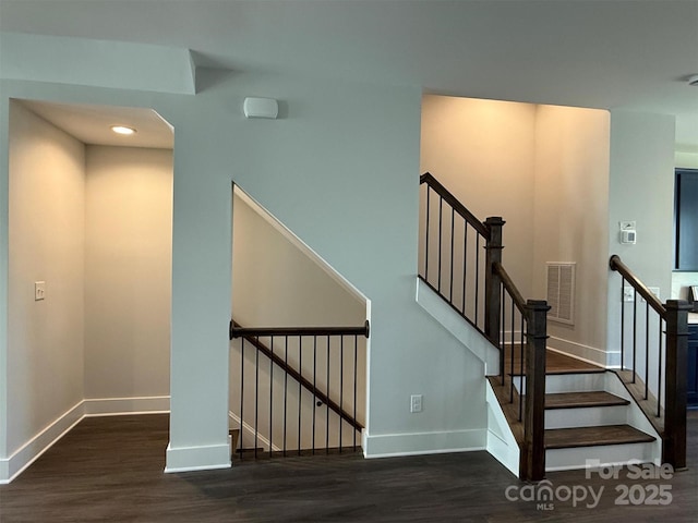 staircase with visible vents, baseboards, and wood finished floors