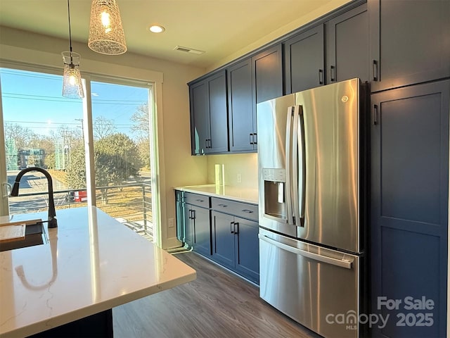 kitchen featuring decorative light fixtures, stainless steel fridge, dark hardwood / wood-style flooring, and sink