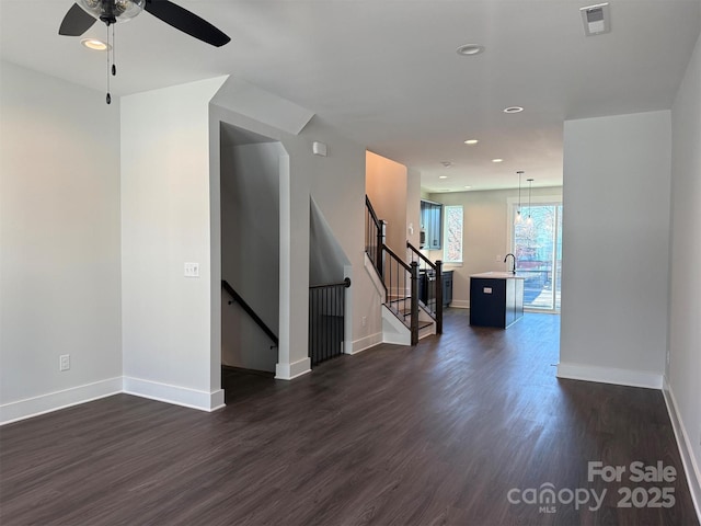 empty room featuring dark hardwood / wood-style floors, ceiling fan, and sink