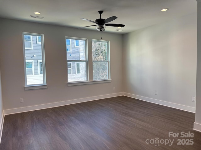 unfurnished room featuring visible vents, recessed lighting, dark wood-type flooring, and baseboards