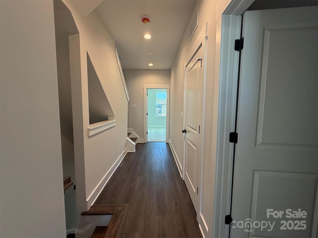 hallway with dark wood-type flooring, recessed lighting, baseboards, and visible vents