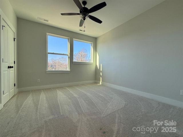 unfurnished bedroom with baseboards, carpet floors, visible vents, and a ceiling fan